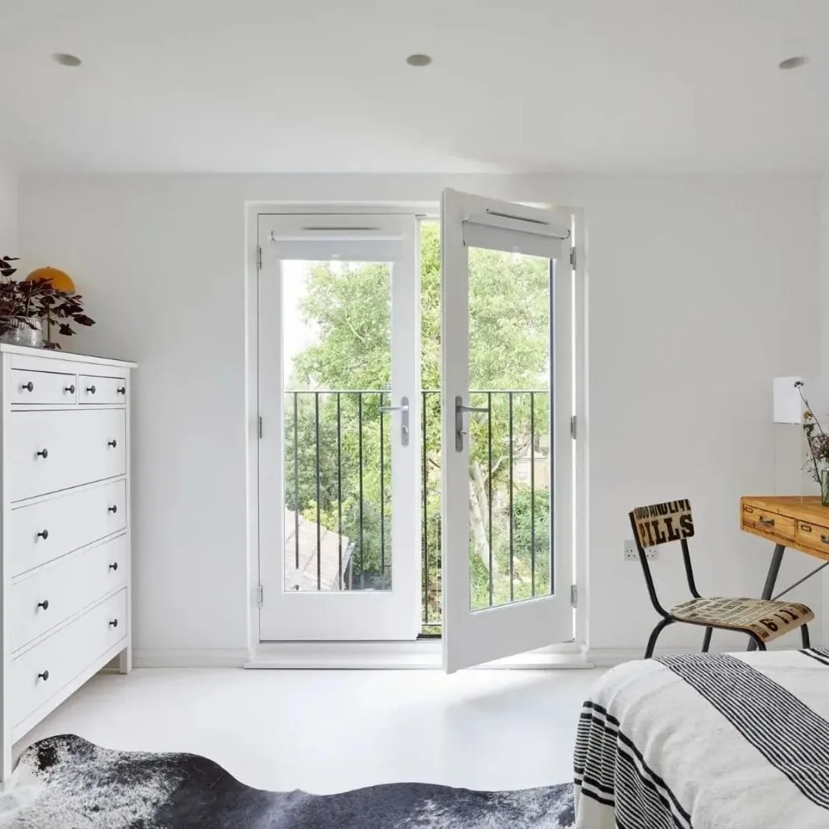 Mansard loft conversion guest bedroom in Kensington with Juliet balcony and modern interior